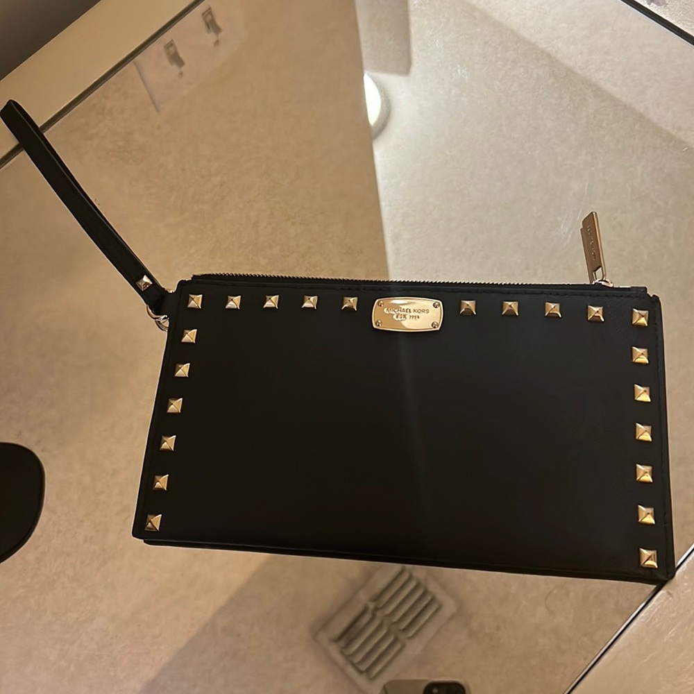 Black Michael kors wristlet with gold studs and hardware.